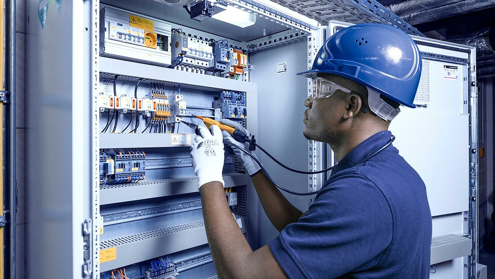 Leadec employee repairing control cabinet.